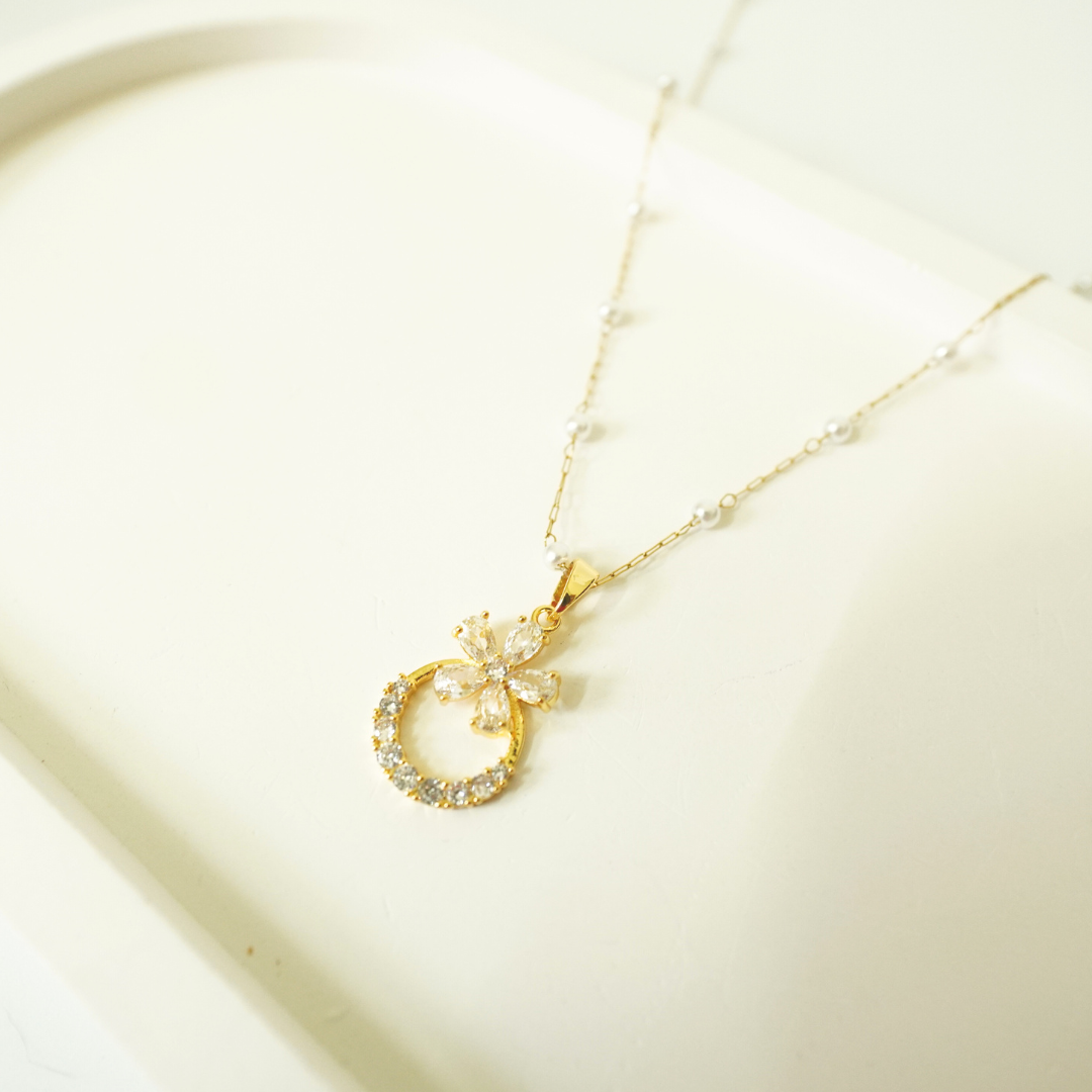 Gold-plated butterfly and circle pendant necklace with sparkling cubic zirconia stones and pearl-studded chain — elegant, anti-tarnish jewelry for special occasions.